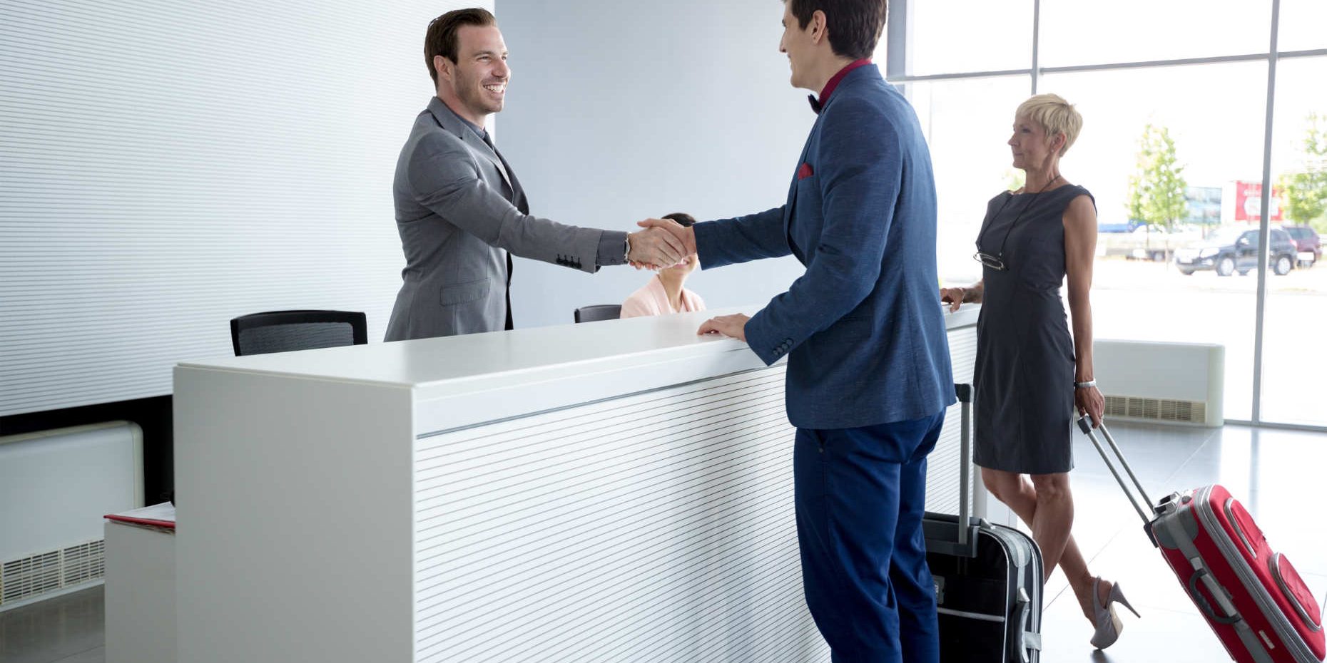 Man and receptionist handshake at reception hall